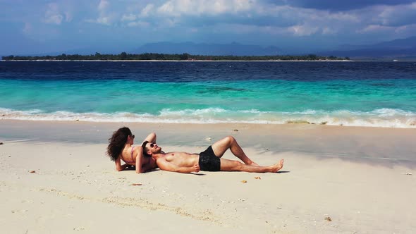 Fun Boy and Girl on Honeymoon Vacation Live the Dream on Beach on Clean White Sand Background  alt
