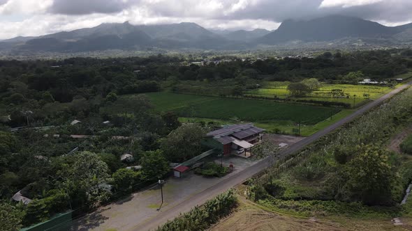 Cinematic aerial footage orbiting and revealing Arenal volcano and Cerro chato in background with he alt