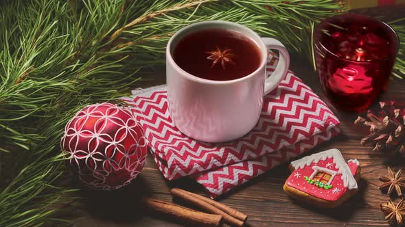 Cup of fruit tea and Christmas decorations on wooden table