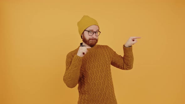 Funny Guy Pointing with His Fingers to the Right Side of the Screen  Orange Background alt