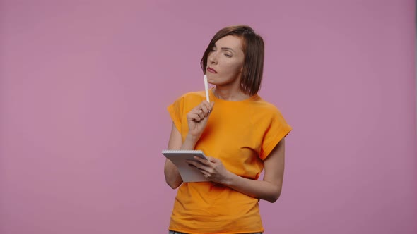 Portrait of Charming Model is Thinking with Concentration Writing Thoughts and Ideas in Notebook alt