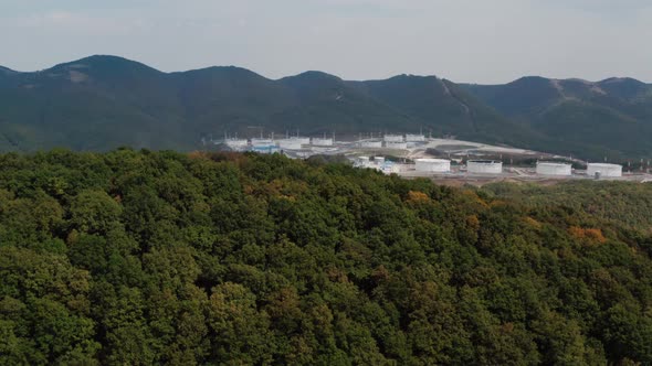 Large tank farm in the mountains with dense vegetation alt