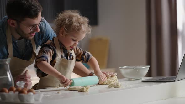 Cute Toddler with Funny Curls is Playing at Kitchen Rolling Out Dough Masterclass From Father Dad alt