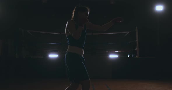 Professional Beautiful Female Boxer Shoots Off Conducting a Shadow Fight in a Dark Hall Room in Slow alt