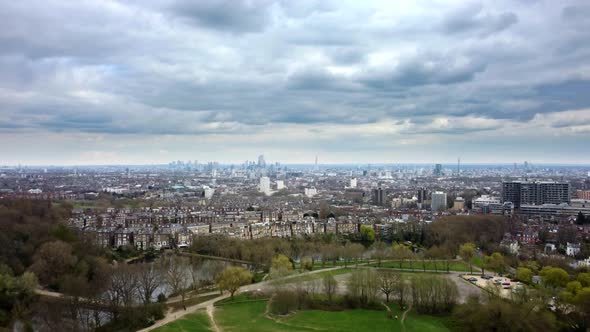 Wide aerial view of City of London from Hampstead Heath on cloudy day alt
