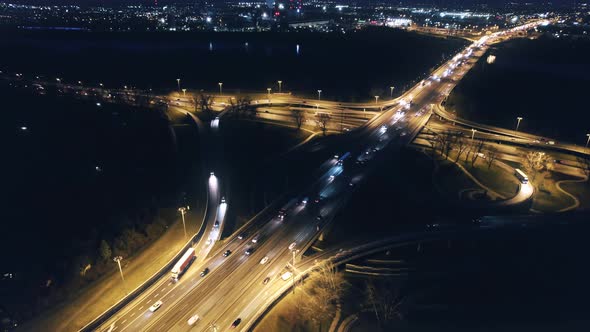 Illuminated road intersection at night in Warsaw, Poland. Aerial drone view. Reveal, dolly out. alt