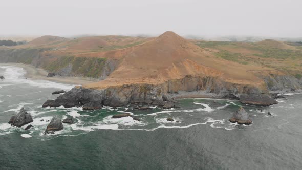 Expansive aerial view of a large hill along the Sonoma Coast in California. alt