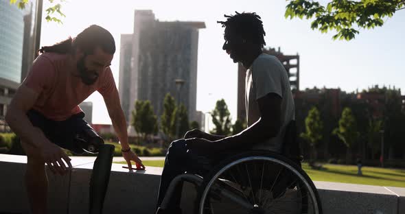 Multiethnic friends with disability greeting each other at city park ...