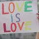 Close-up of Raised Love Is Love Banner in Female Caucasian Hands. Unrecognizable Lesbian Activist - VideoHive Item for Sale