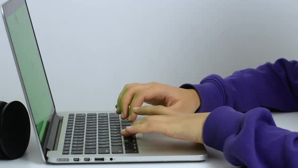 Hands of a mixed-race woman writing a text on a laptop keyboard in close-up