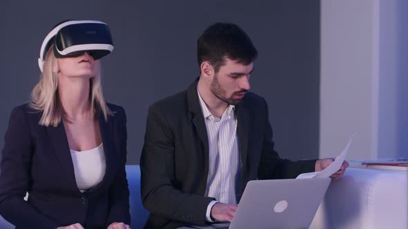 Blonde Woman in VR Headset Discussing Construction Project with Her Partner alt