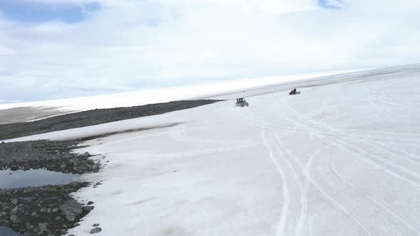 People Leisurely Riding Vehicles In Snowy Landscape Of Langjokull - aerial shot alt