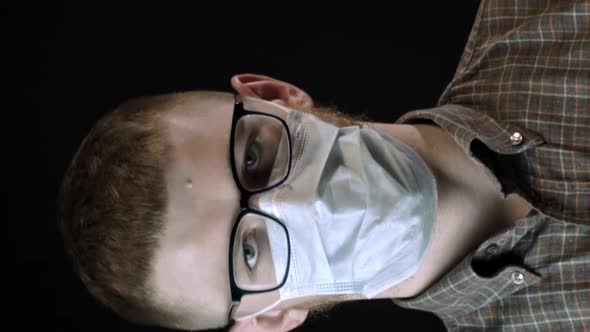 Vertical Shot Young Man in Medical Mask Against Covid19 Looks at Camera