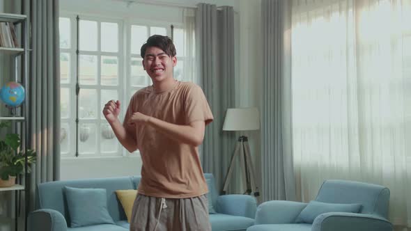 Asian Man Dancing While Shooting Video Content For Social Networks At Home alt