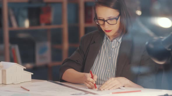 Professional Female Architect Drawing Floor Plan and Posing for Camera alt