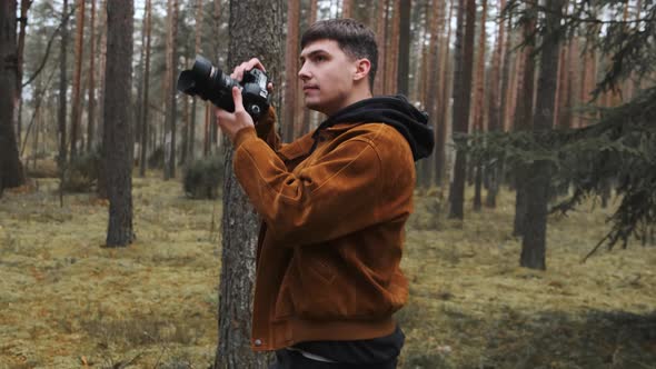 A Photographer Takes Pictures in the Woods a Young Man Takes Pictures in the Woods with His Camera alt