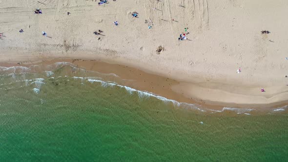 Top down aerial footage of the Bournemouth beach showing people relaxing on the beautiful beach alt