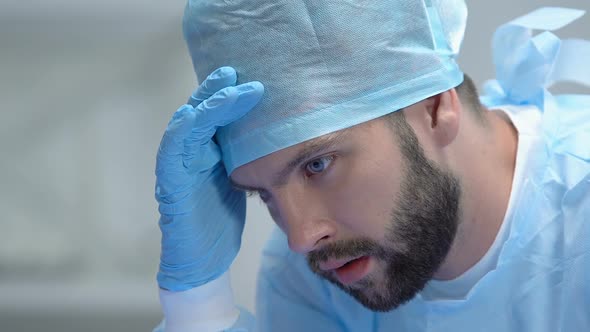 Thoughtful Male Doctor in Protective Uniform, Responsible Decision, Emergency alt