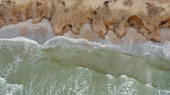 Aerial View of Stormy Waves Beating Against a Rocky Shore on a Sandy Tropical Beach alt