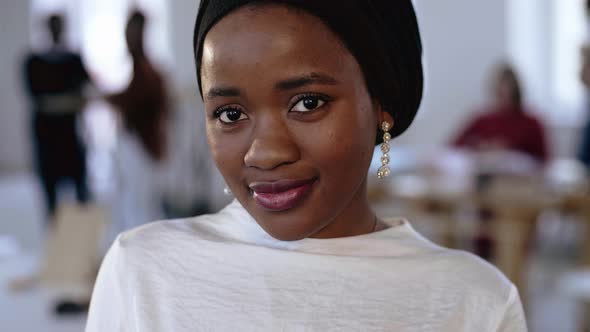 Close-up Portrait of Young Happy African Business Woman in Ethnic Headwrap Posing, Smiling at Modern