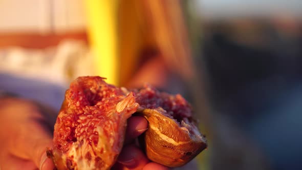 Woman's Hands Opening a Fig to Eat alt