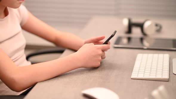 Girl Playing Games on Her Modern Smartphone Device alt