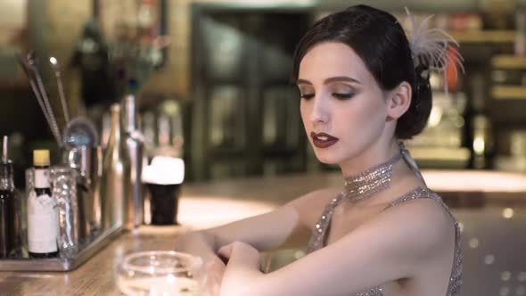 Closeup Portrait of a Young Attractive Woman in a 1920s Style Drink Wine or Champagne at the Bar alt
