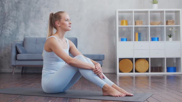 Young and sporty girl in sportswear is doing exercises at home. alt