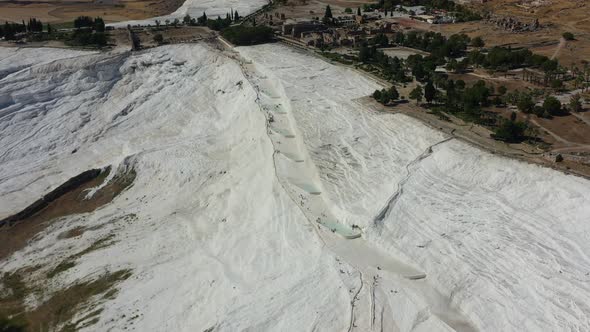 top down aerial view of tourists walking on the white mineral rich mountain hill where only a few th alt