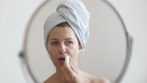 Woman applying wax lip balm salve product 4K 2160p 30fps UltraHD footage - Blonde healthy female in 