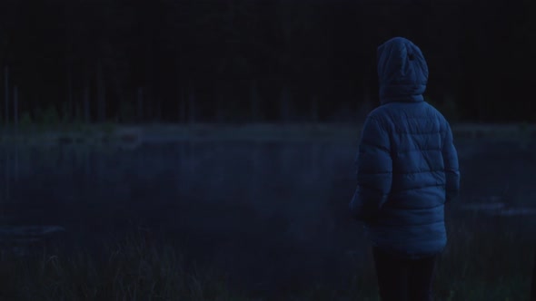 person watching a fog rolling over the lake at night, dark moody atmosphere alt