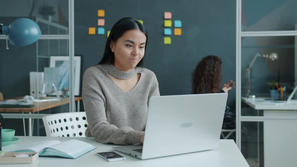 Irritated Asian Employee Using Laptop Typing Then Leaving Workplace Feeling Angry and Unhappy alt