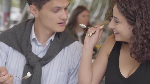 Portrait of a Happy Couple Eating Desert Sitting in Cafe Outdoors alt