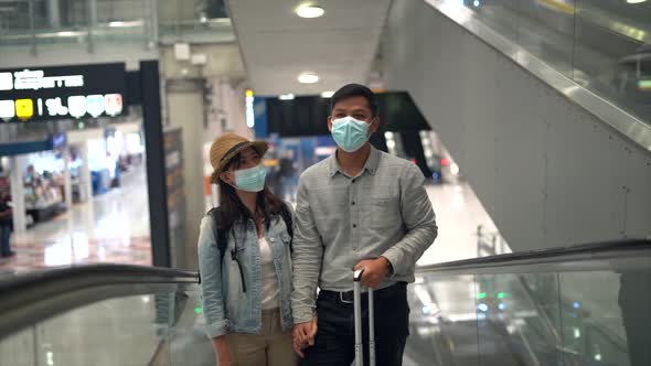 Couple Asian people walking in airport terminal waiting for  flight boarding