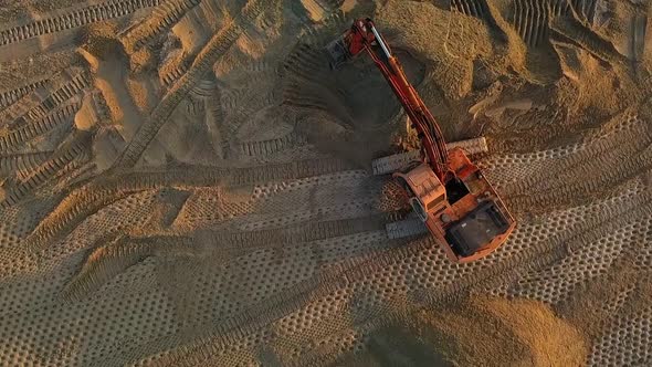 Excavator at Work Leveling the Surface with Sand at a Construction Site Top View