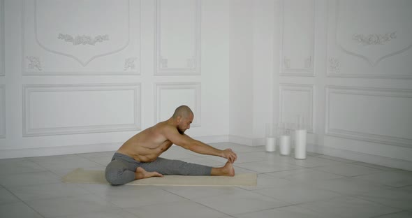 Muscular Male Yogi Doing Leg Stretching. He Sprains His Left Leg alt
