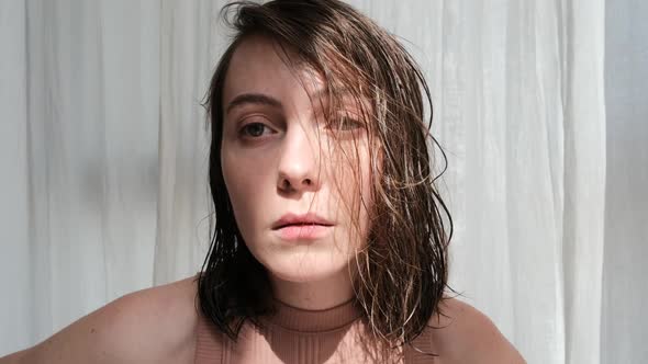 Worried Woman with Brown Wet Hair Near White Window Curtain alt