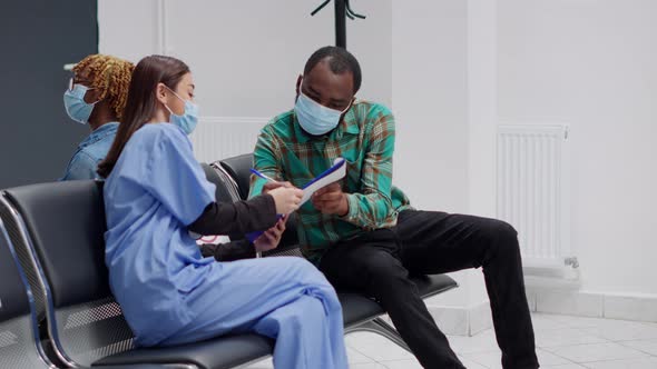 African American Patient Filling in Medical Report to Attend Checkup Appointment alt