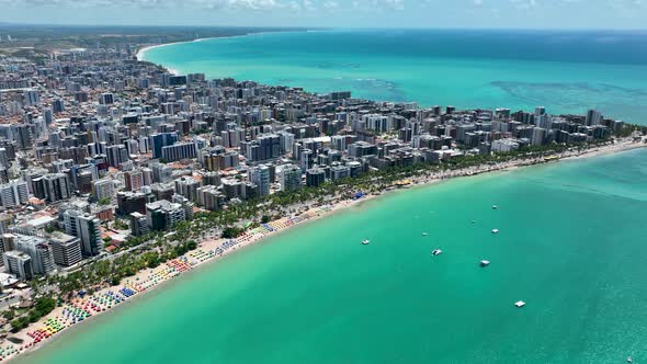 Aerial panning shot of turquoise water beach at Maceio Alagoas Brazil. alt