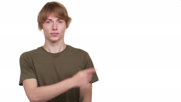Portrait of Upset Guy in Tshirt Expressing Dislike with Gesturing Thumb Down at Something Copy Space alt