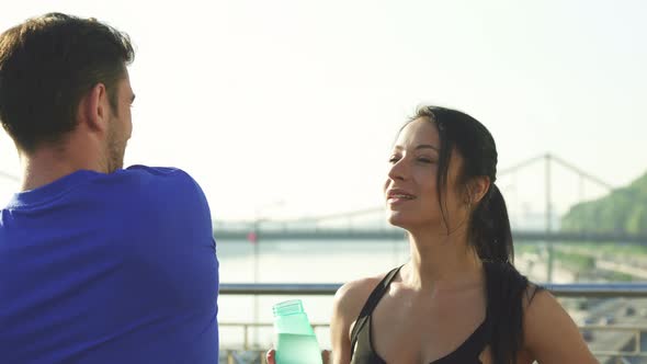 Beautiful Young Woman Talking To Her Male Friend While Working Out Together alt