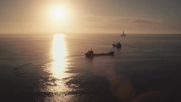 Cargo Ships Silhouette Sailing in Sunset Ocean