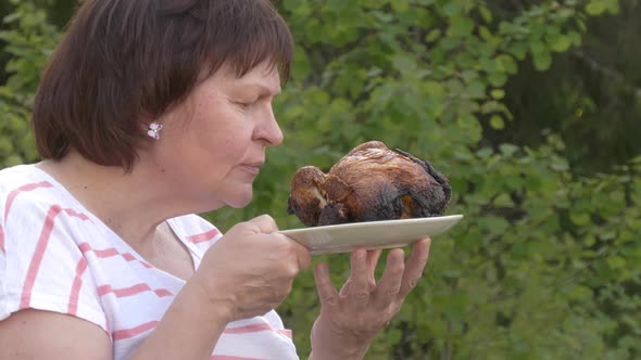 Beautiful Shot of a Middleaged Lady Smelling a Grilled Chicken