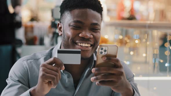 Satisfied African American Man Makes Purchase in Online Store Pays for Goods with Credit Card on alt