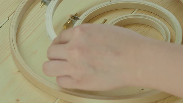 Embroidery framing by hand. Wood frame embroidery hoop. Red color fabric framed with wooden hoop. alt