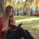 Woman Reading Book In Autumn Park Under The Tree - VideoHive Item for Sale