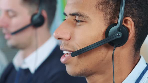 Close-up Shot of Mixed-race Man in Headset Talking To Somebody in Office alt