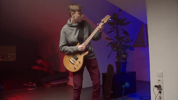 Energetic Young Man Playing Rock Music on Guitar