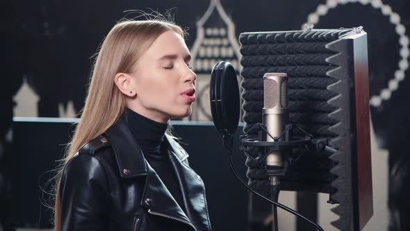 Close Up of Lovely Blonde Girl Is Recording a Song in a Recording Studio