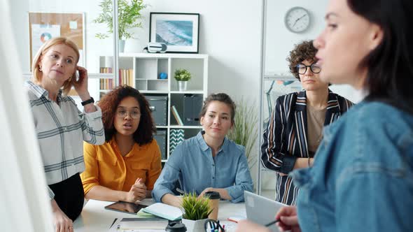 Businesswoman Making Presentation Giving Good News To Employees Talking Indoors in Office alt